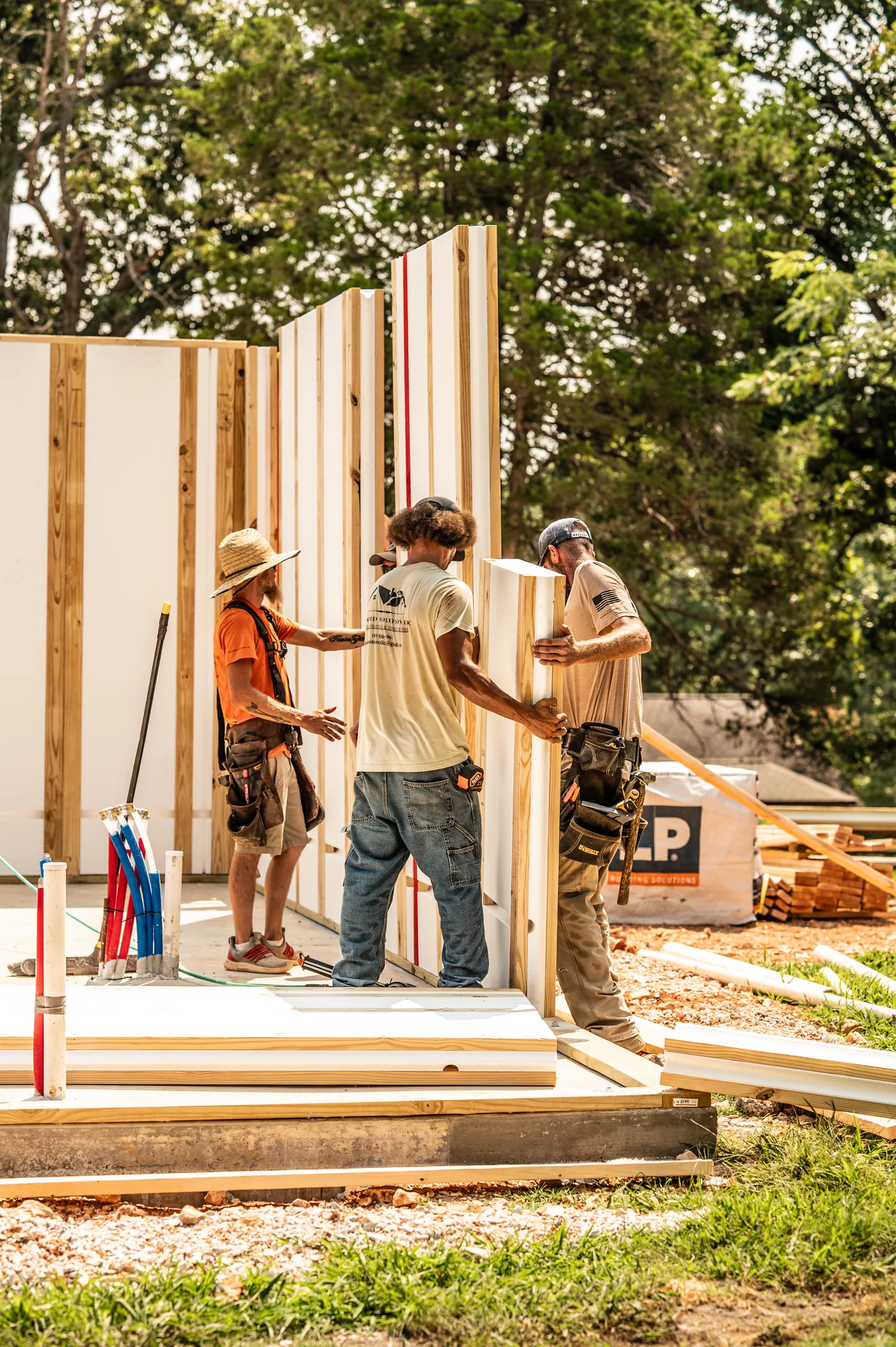 Crew positioning an IFP insulated wood-framed wall panel on a home under construction